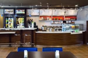 a bar in a restaurant with tables and blue stools at Courtyard St. Louis Airport/Earth City in Bridgeton