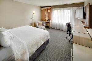 a hotel room with a bed and a television at Courtyard St. Louis Airport/Earth City in Bridgeton