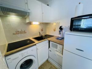 cocina pequeña con lavadora y microondas en Appartement Cap d'Agde, 2 pièces, 4 personnes - FR-1-723-83, en Cap d'Agde