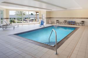a pool in a hotel lobby with tables and chairs at Courtyard by Marriott Wayne Fairfield in Wayne