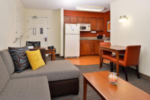 a living room with a couch and a table and a kitchen at Residence Inn by Marriott Loveland Fort Collins in Loveland