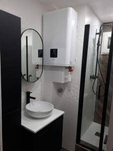 a white bathroom with a sink and a mirror at Charmant appartement proche de la défense in Rueil-Malmaison