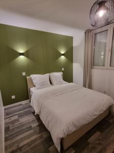 a bedroom with a large bed with a green wall at Charmant appartement proche de la défense in Rueil-Malmaison