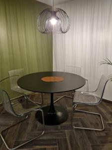 une table et des chaises dans une pièce dotée d'un lustre dans l'établissement Charmant appartement proche de la défense, à Rueil-Malmaison