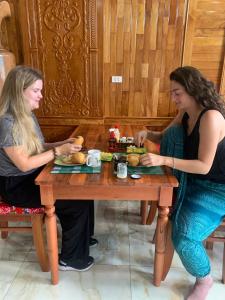 two women sitting at a table eating food at Sun Hà Giang Hotel-tours-motorbike rental in Ha Giang