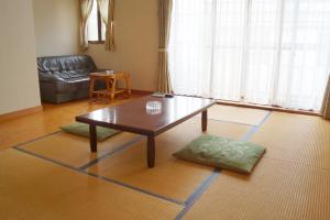 un soggiorno con un tavolino da caffè e un divano di タートルハウス a Shimoda