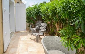 dwa krzesła siedzące na patio z roślinami w obiekcie 3 Bedroom Gorgeous Home In Portiragnes w mieście Portiragnes +20 zdjęć