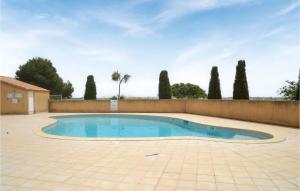 a swimming pool in a yard with a fence and trees at Amazing Home In Portiragnes With Outdoor Swimming Pool And 3 Bedrooms in Portiragnes