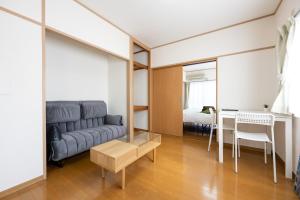 sala de estar con sofá y mesa en コーポウメザキ, en Ogikubo