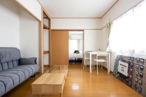 sala de estar con sofá y mesa en コーポウメザキ, en Ogikubo