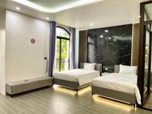 1 dormitorio con 2 camas y ventana grande en Villa 7PN sát biển tại Hạ Long en Ha Long