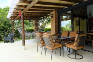 a patio with chairs and a table and a hammock at Fincas Panaca Herreria 1 - San Judas in Quimbaya