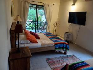 a bedroom with a bed and a television and a balcony at Fincas Panaca Herreria 1 - San Judas in Quimbaya +9 photos