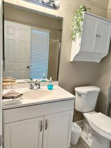 a bathroom with a sink and a toilet and a mirror at Cozy Bohemian Home w/ Hot Tub in Mesa in Mesa