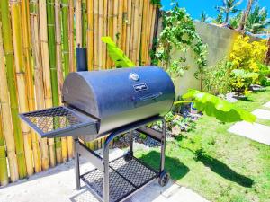 a bbq grill sitting in front of a fence at Casa Basa Siargao in General Luna