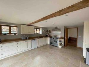 a large kitchen with white cabinets and an attic at Charming Norfolk Barn Conversion in Barnham Broom in Norwich