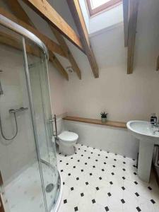 y baño con ducha, aseo y lavamanos. en Charming Norfolk Barn Conversion in Barnham Broom en Norwich