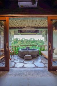 a bathroom with a tub on a screened in porch at Kastara Resort in Ubud