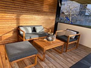 un patio con 2 sillas, un sofá y una mesa en Appartement Two en Ötztal-Bahnhof