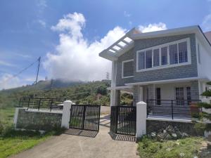 a house with a gate in front of a mountain at Chill Breeze Castle - 4BHK Villa with Captivating city view & Mountain view, Wifi, Campfire, Homemade Food in Kodaikānāl