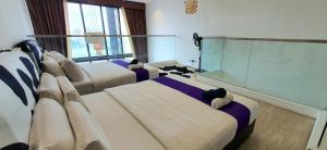 een hotelkamer met 3 bedden en een groot raam bij M City Ampang Infinity Pool KLCC in Kuala Lumpur