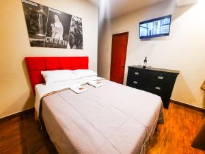 sypialnia z dużym łóżkiem z czerwonym zagłówkiem w obiekcie Brianny Hotel w mieście Churin