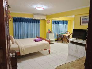 1 dormitorio con 1 cama, TV y mesa en ARIZONA BEACH RESORT, en Olóngapo