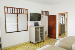ein Wohnzimmer mit einem TV und ein Zimmer mit einem Bett in der Unterkunft Casa Montero, acogedora y amplia. Iquitos-Peru in Iquitos