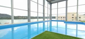 una piscina con agua azul y ventanas en Amplio apartamento lujoso al lado del lago, en Paipa