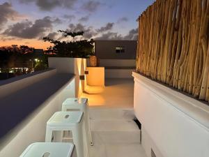 Un balcón con escaleras y taburetes en un edificio en Xikama Studios by Andiani Travel en Cancún