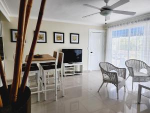 a living room with a table and chairs and a television at 2 bedrooms, 2 bathrooms, pool and near from the beach in Juan Dolio