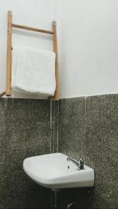baño con lavabo y toalla blanca en Tiara Homestay en Plambi
