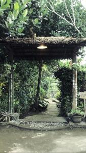 una entrada a un jardín con un arco de madera en Tiara Homestay en Plambi