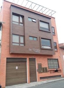 ein großes Backsteingebäude mit zwei Garagen und zwei Garagentüren in der Unterkunft Departamento 2B en Condominio La Victoria in Cuenca
