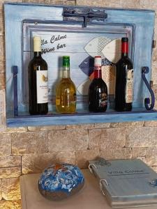a shelf with bottles of wine on a wall at Symi . VILLA CALME (Sur la Mer). in Symi