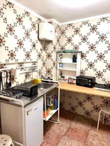 uma cozinha com papel de parede floral e um balcão em Casa Di Sylwia em Termini Imerese