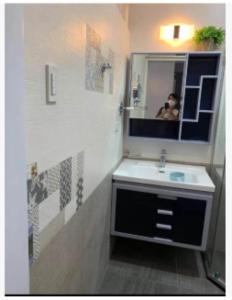 een badkamer met een wastafel en een spiegel bij Quirino hub 2 BR family room in Davao City
