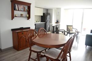 a kitchen and dining room with a wooden table and chairs at Amplio apartamento lujoso al lado del lago in Paipa