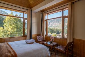 a bedroom with a bed and a large window at Urban Monk- Highest Stay and Cafe of Manali in Manāli