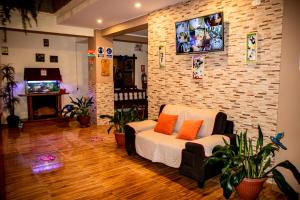 a living room with a couch and a tv on a brick wall at Hospedaje Chimy in Oxapampa