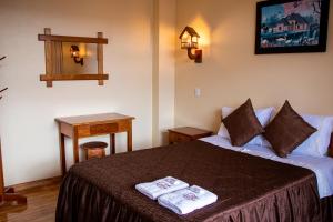 a hotel room with a bed with two towels on it at Hospedaje Chimy in Oxapampa +83 photos