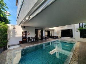 a swimming pool in front of a house at Cheeva Dee Hotel in Chiang Mai