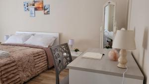 ein Schlafzimmer mit einem Bett und einem Tisch mit einer Lampe in der Unterkunft B&B SoleMare in Taranto