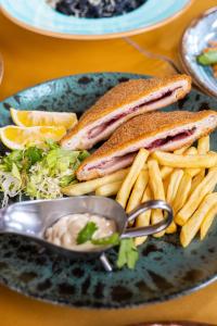 a plate with a sandwich and french fries and dip at HOTEL EMROVIC RAJ in Novi Pazar