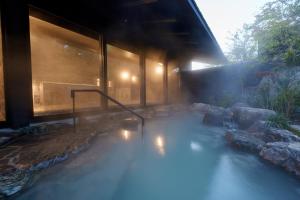 a house with a hot tub in the middle at Unzen Miyazaki Ryokan in Unzen