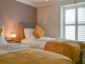 a bedroom with two beds and a window at Willow Cottage in Cockermouth