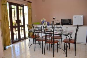 a dining room with a table and chairs and a kitchen at Royal Apartments in Nuwara Eliya +22 photos