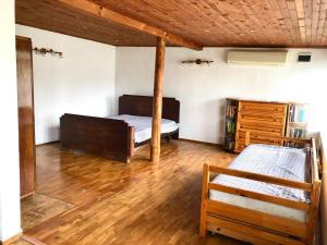 1 dormitorio con 2 camas y suelo de madera en Самостоятелна къща за гости на 10 минути от плажа en Varna