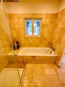 a bathroom with a tub and a window at Centre San Peire Les Issambres in Les Issambres