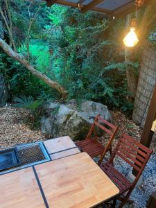 drewniany stół i dwa krzesła pod dachem w obiekcie HOSHIYAMA B extra for pets - Vacation STAY 13934v w mieście Fujinomiya